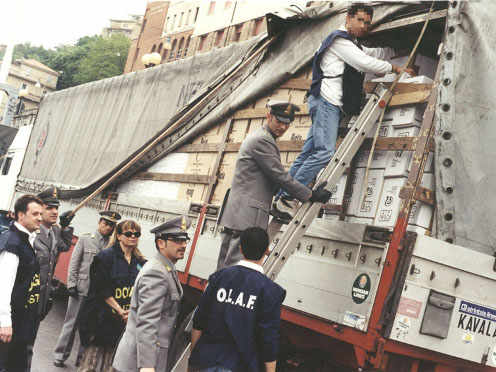 carabineros italianos y miembros de OLAF inspeccionan un camión