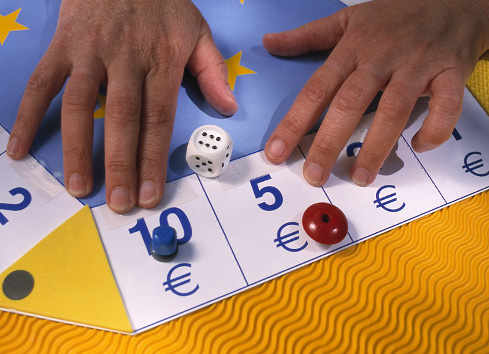 Un tablero con euros en las casillas y unas fichas