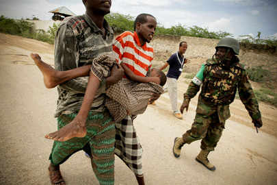 un soldado de la ONU lleva corriendo a un adolescente desvanecido