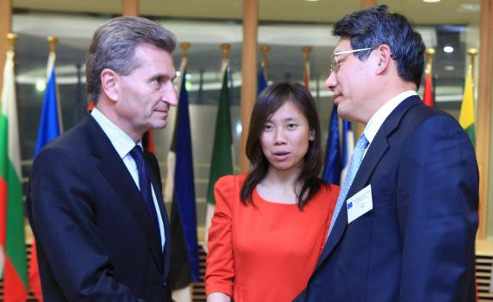 El comisario europeo de energía y el director de la Agencia China de la Energía se saludan