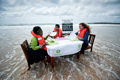 Tres activistas sentados en una mesa en medio del mar