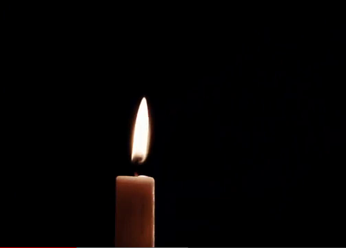 Una vela encendida sobre fondo negro
