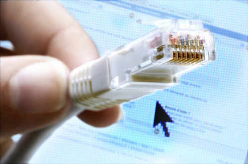 Una mano sujeta un conector de internet