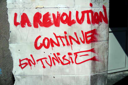 Una pintada en la pared que dice La revolución continúa en Túnez