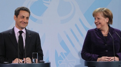 Angela Merkel y Nicolas Sarkozy en la rueda de prensa, se miran sonrientes