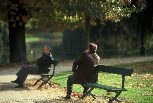 Dos hombres sentados en un banco del parque