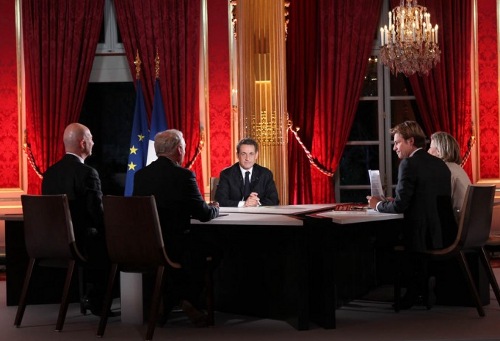Sarkozy en la mesa de la entrevista con cuatro periodistas