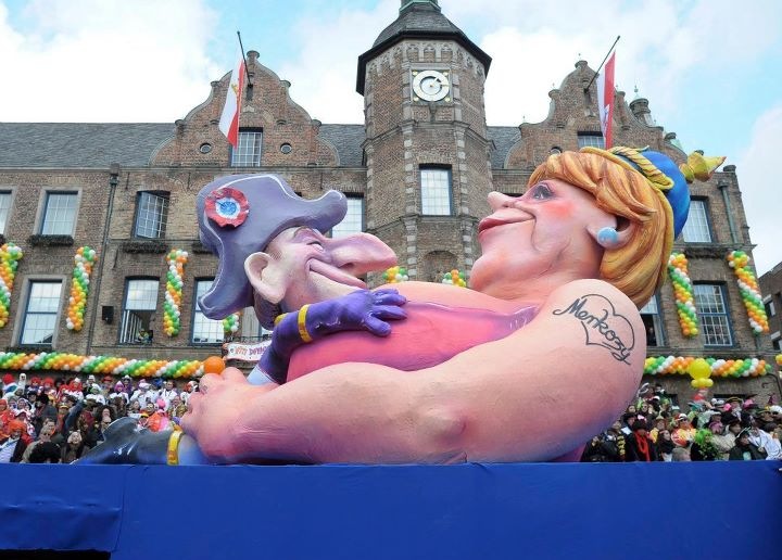 Figura de carnaval, el presidente Sarkozy encima del pecho de la canciller Merkel