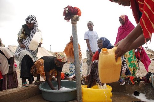 Mujeres llenan las vasijas de agua