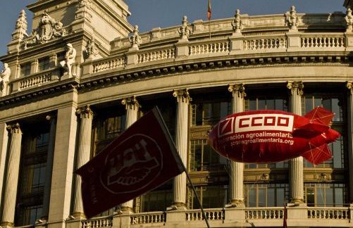 un pequeño globo con las siglas de CC OO y una banderola con las de UGT sobre un edificio del centro de Madrid