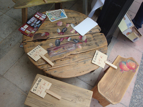 Una mesa, sillas y otros objetos con anuncios de su precio en Kaeretis