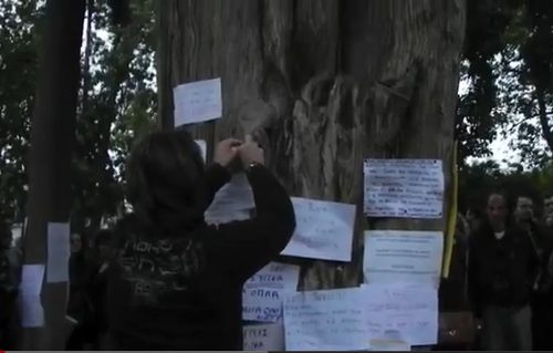 Un joven pega una nota en el árbol junto al que se suicidó Dimitri Christoulas