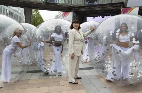 Unas chicas dentro de unas bolas transparentes rodean a la comisaria