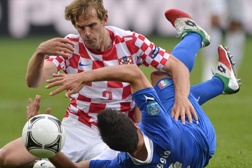 El croata Strinic y el italiano Maggio luchan por un balón