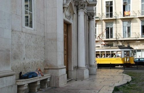 Un hombre durmiendo en un banco en la calle