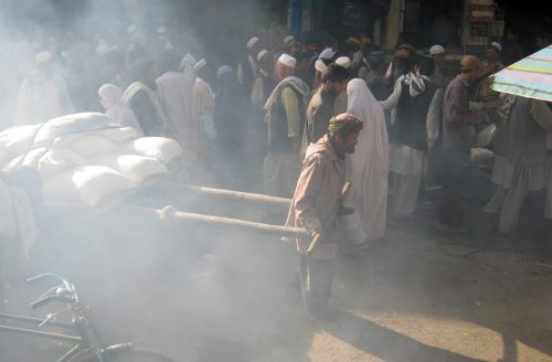 Actividad en la calle, entre una nube de humo hombres y mujeres 