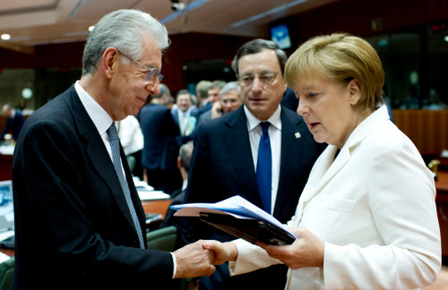 Mario Monti y Angela Merkel se saludan en presencia de Mario Draghi. Merkel mira unos papeles