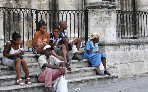 Grupo de personas sentados en una escalera de La Habana