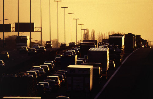 Una carretera al atardecer llena de coches y camiones