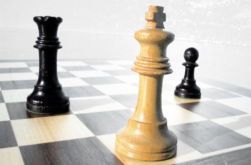 Un tablero de ajedrez con tre piezas: rey blanco, alfil y peón negros