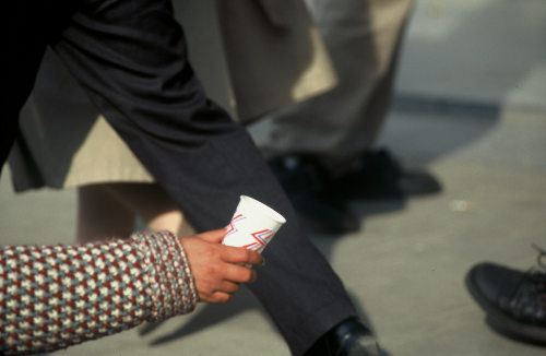Un mendigo pide con un vaso de plástico