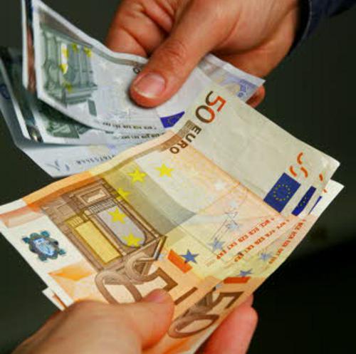 Foto simbólica de billetes de euro que pasan de una mano a otra