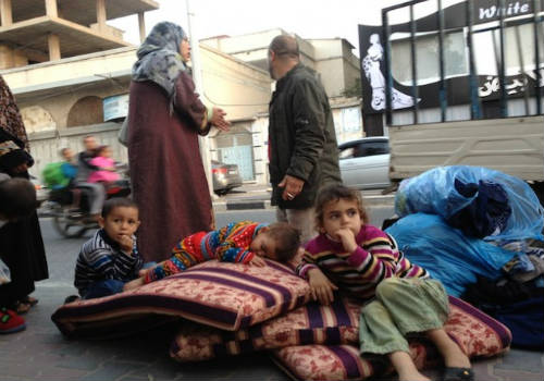 Familia palestina en la calle con mantas