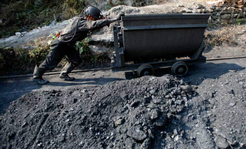Minero empuja una vagoneta de carbón