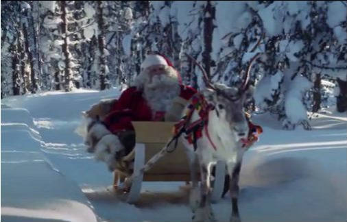Santa Claus en trineo tirado por un reno entre abetos nevados