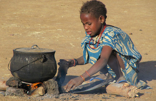 Una niña cocina en el suelo