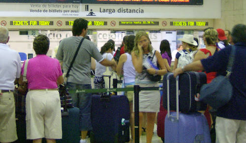 Personas en una estación de tren con maletas