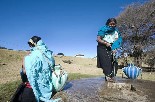Mujeres indígenas en San Cristobal de las Casas sacando agua de un pozo