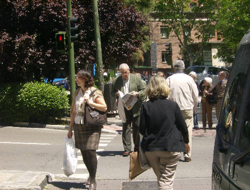 Peatones cruzando con el semáforo en rojo