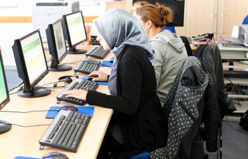 Chicas trabajando con ordenadores una de ellas con hijab
