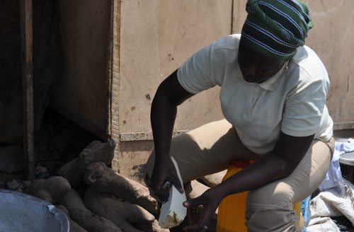 Una mujer africana preparando mandioca