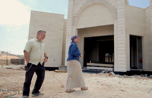 Moshe Goldshmidy y su esposa delante de un edificio en construcción