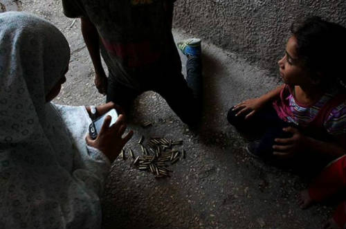 Niños palestinos jugando entre balas