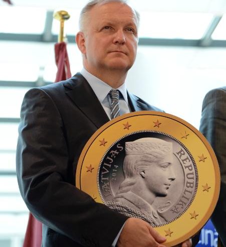 Olli Rehn con una moneda gigante de euro 