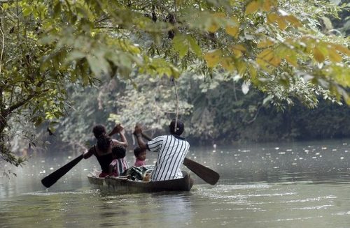 Una familia en una barca de remos navegan por el río