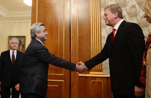 El presidente armenio y el comisario europeo se saludan
