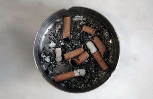 Un cenicero con colillas de cigarrillos