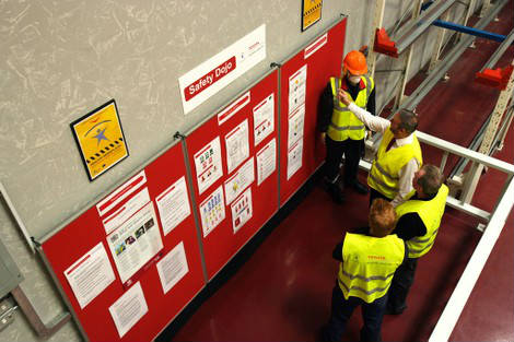 Trabajadores mirando paneles de seguridad laboral