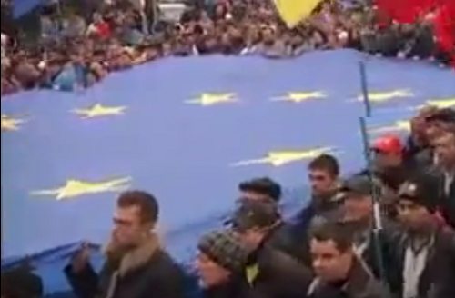 Manifestantes llevan una enorme bandera de la UE