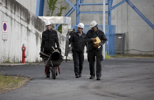 Tres trabajadores en una planta de enería de carbón 