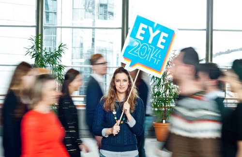 Una joven con una pancarta que dice EYE 2014