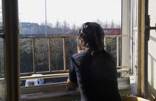Una mujer mira por una ventana