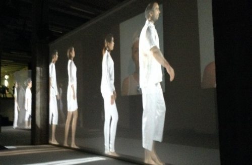 Un panel con diferentes personas vestidas de blanco de espaldas al espectador