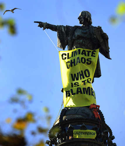 estatua de Colón con una pancarta de Greenpeace