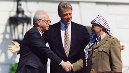 Yitzak Rabin y Yasser Arafat se estrechan la mano en presencia de Bill Clinton
