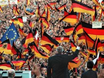 El ex canciller de espaldas ante una multitud con banderas alemanas y europea